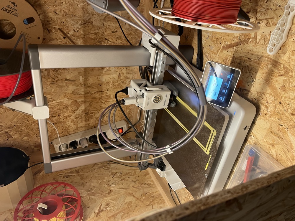 Una stampante 3D mentre stampa un telaietto giallo